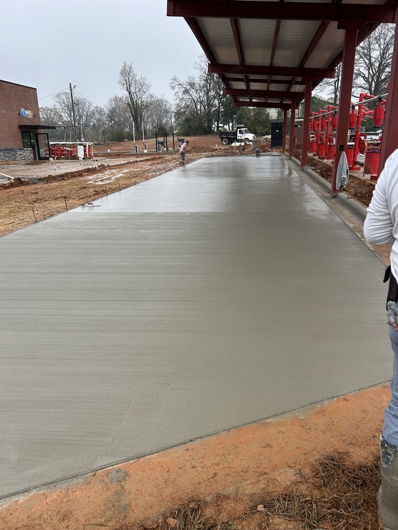 Santiz crew member applying broom finish to commercial concrete pad