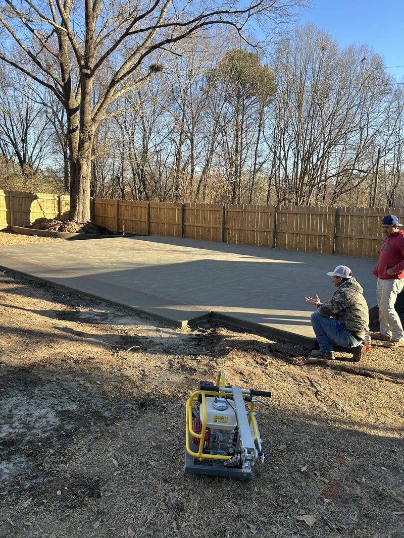 Concrete contractors inspecting newly poured residential concrete pad in Spartanburg SC