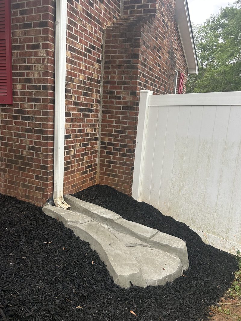Custom concrete splash block drainage repair solution at residential home in Spartanburg SC