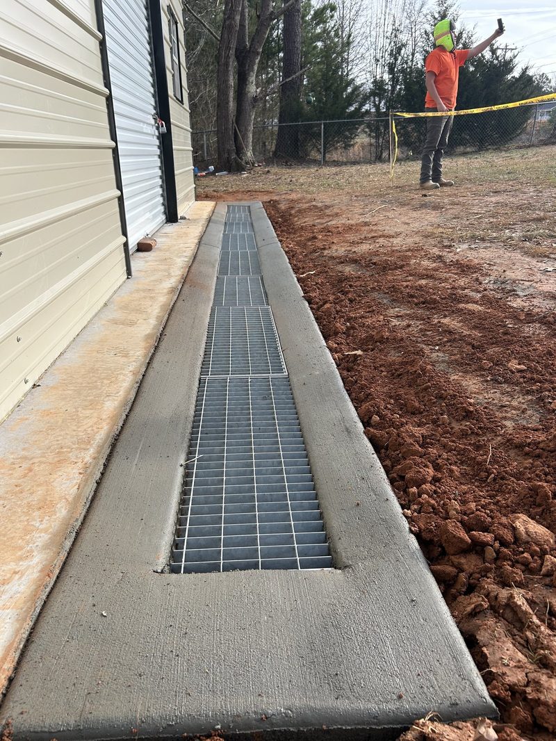 Newly installed concrete trench drain with metal grates by Santiz Concrete